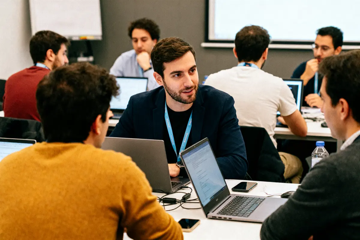 Des étudiants discutent lors d'une formation en stratégie digitale à Webcampus sur la durée.