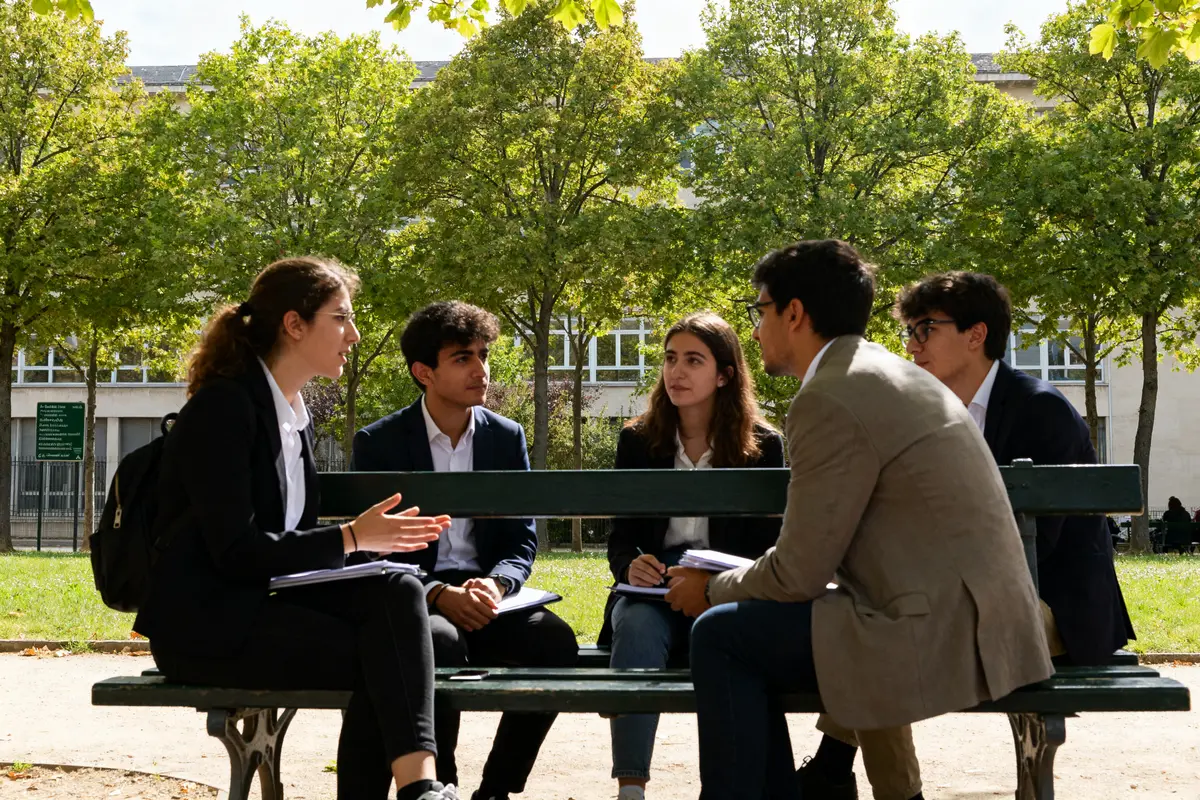 Étudiants discutant en plein air sur le campus de l'université Paris-Dauphine.